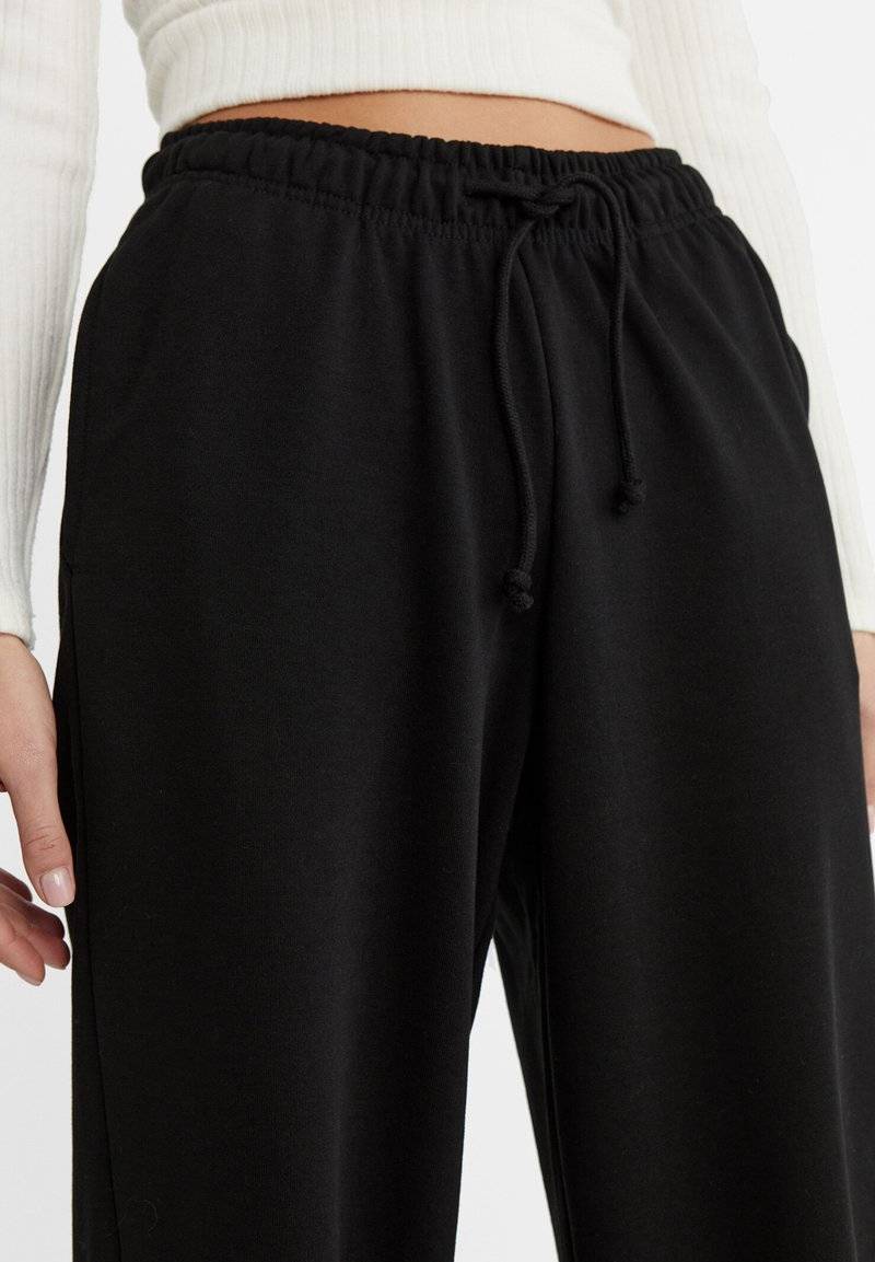 Stradivarius Stradivarius WIDE-LEG JOGGER - Tracksuit bottoms - black Großer Ausverkauf