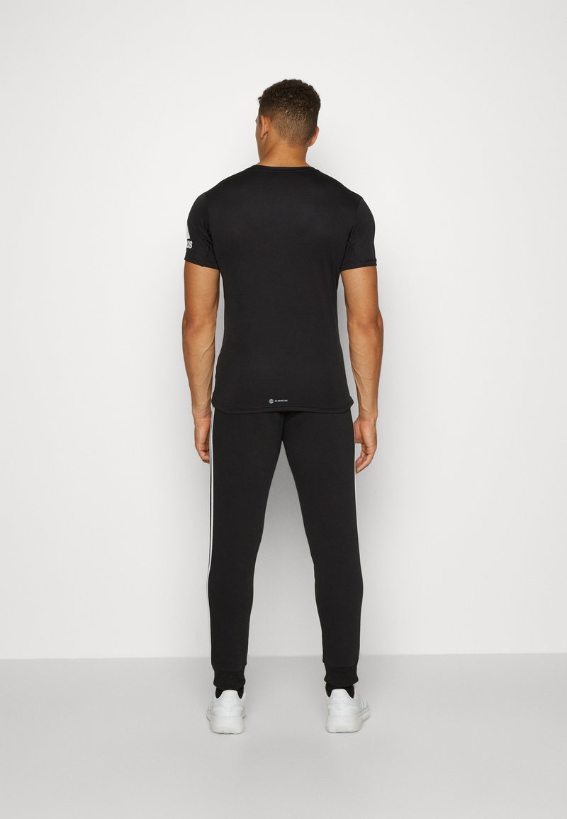 adidas Sportswear adidas Sportswear ESSENTIALS TAPERED CUFF 3 STRIPES PANTS - Tracksuit bottoms - black white Jubiläumsangebot