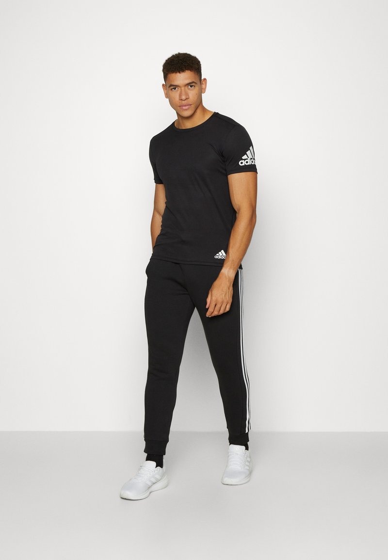 adidas Sportswear adidas Sportswear ESSENTIALS TAPERED CUFF 3 STRIPES PANTS - Tracksuit bottoms - black white Jubiläumsangebot